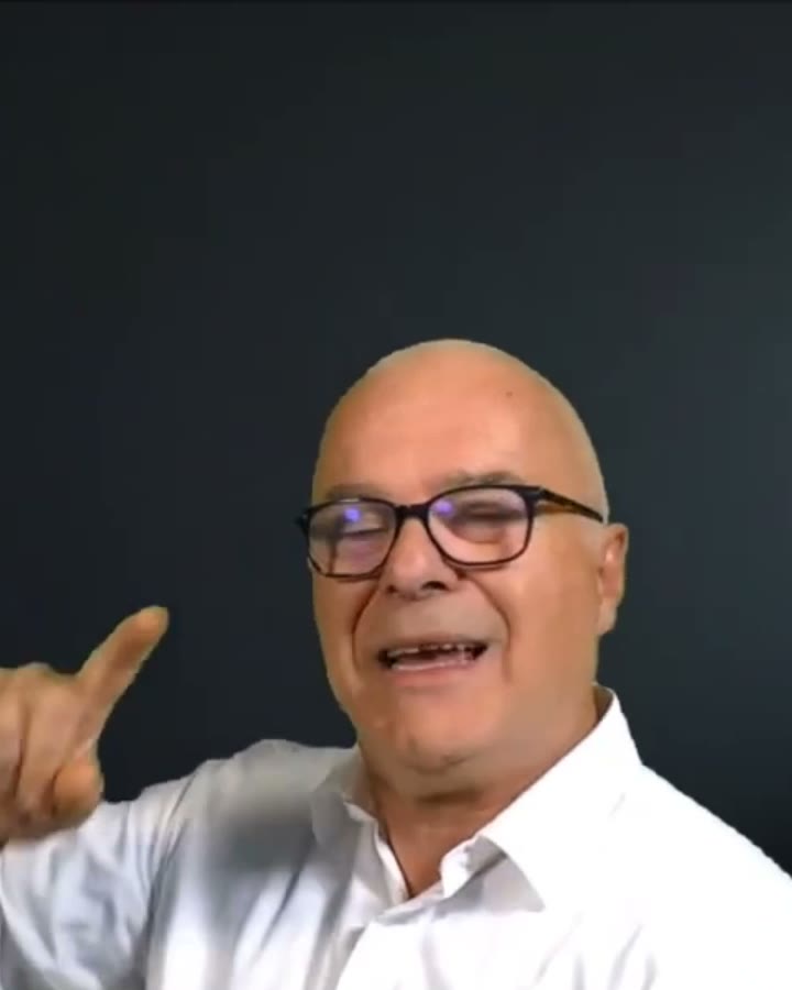 Federico Coppola sorride e alza un dito, mentre spiega in camera